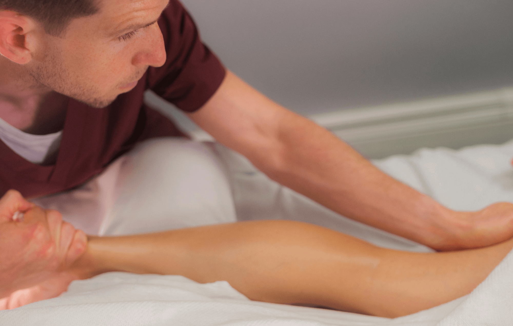 Massage therapist performing Swedish massage on a leg